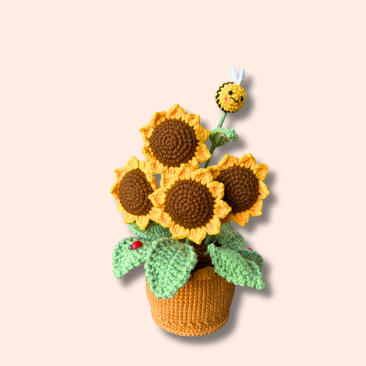 Handmade crocheted sunflower plant with a bee